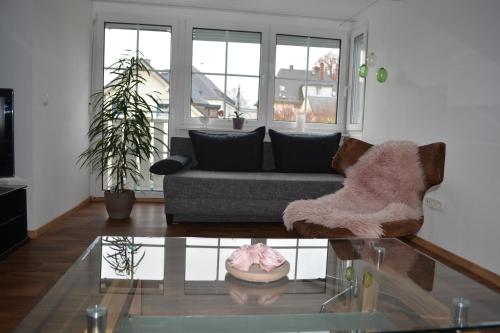 a living room with a couch and a glass table at Fewo Bauer in Oberkotzau