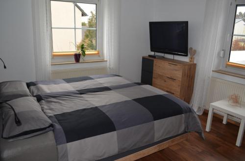a bedroom with a bed and a flat screen tv at Fewo Bauer in Oberkotzau