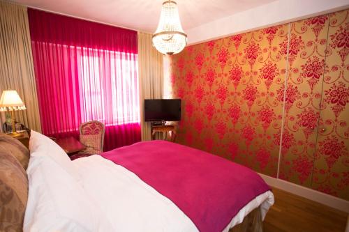 a bedroom with pink walls and a bed with a pink blanket at Townhouse Boutique Hotel in Zürich