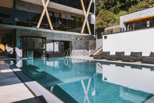 a swimming pool in the middle of a house at GLEMM by AvenidA Superior Hotel & Residences in Saalbach Hinterglemm
