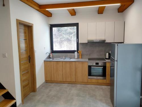 uma cozinha com um frigorífico de aço inoxidável e uma janela em Chata - Alex em Snina