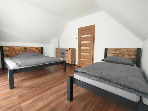 two beds in a room with wooden floors at Chata - Alex in Snina