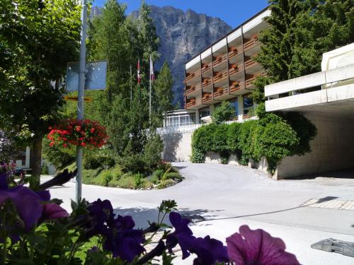 a hotel with flowers in front of a building at Hotel Regina Terme in Leukerbad