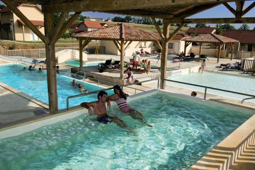 dwoje osób w basenie w ośrodku w obiekcie Belambra Clubs Résidence Rocamadour - Les Portes De Dordogne w mieście Alvignac