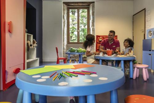 un groupe de personnes assises à des tables dans une pièce dans l'établissement Belambra Clubs Résidence Rocamadour - Les Portes De Dordogne, à Alvignac