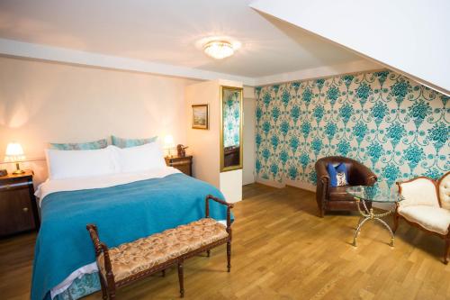 a bedroom with a blue bed and a chair at Townhouse Boutique Hotel in Zürich