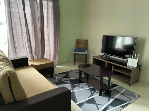 een woonkamer met een bank en een flatscreen-tv bij LA 1 Homestay Putrajaya Dwiputra in Putrajaya