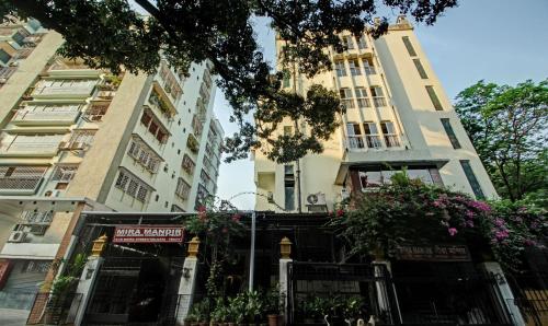 un par de edificios altos con flores delante de ellos en Treebo Trend Mira Inn en Calcuta