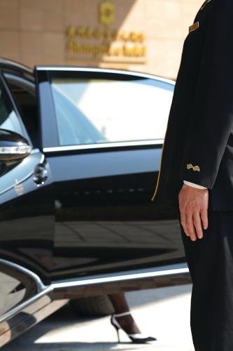 a man in a suit standing in front of a car at Shangri-La Guangzhou-Walking to Canton Fair Complex in Guangzhou