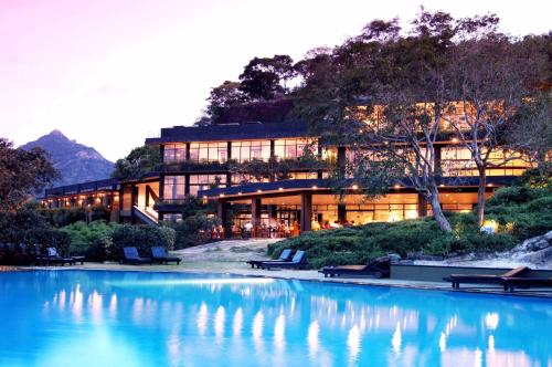 a building with a pool of water in front of it at Heritance Kandalama in Sigiriya