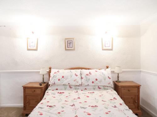 ein Schlafzimmer mit einem Bett und zwei Nachttischen mit Lampen in der Unterkunft The Willow Bed and Breakfast in Pateley Bridge