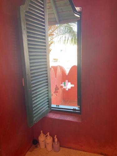 a window in a red wall with vases in front of it at A Fei Surf Inn III in Nanwan