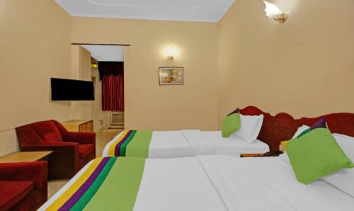 a hotel room with a bed and a red chair at Treebo Mira Inn, Camac Street in Kolkata