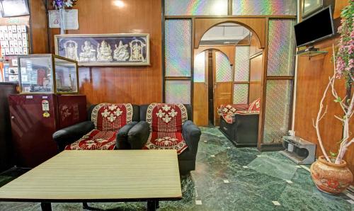 a room with two chairs and a table and a mirror at Treebo Mira Inn, Camac Street in Kolkata