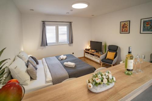 a bedroom with a bed and a table with a bottle of wine at Hotel Smrž in Sepekov
