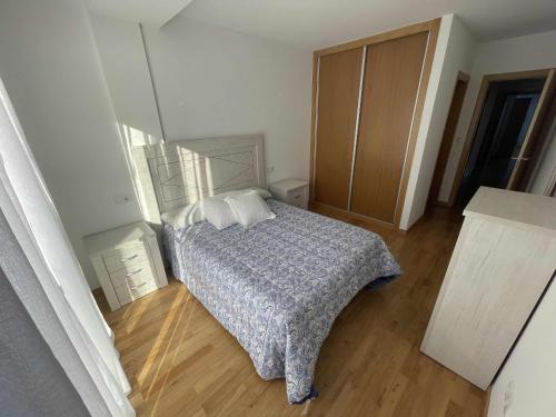 um quarto com uma cama e piso em madeira em Grupo Gontad Apartamento Villa Amparo Laxe em La Coruña