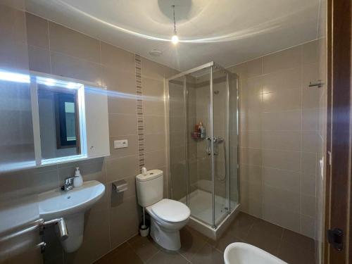 uma casa de banho com um chuveiro, um WC e um lavatório. em Grupo Gontad Apartamento Villa Amparo Laxe em La Coruña