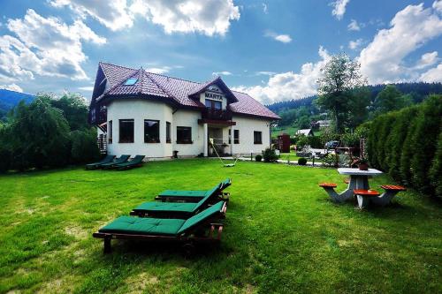 a house with picnic tables in a yard at Pokoje Marta in Międzybrodzie Bialskie