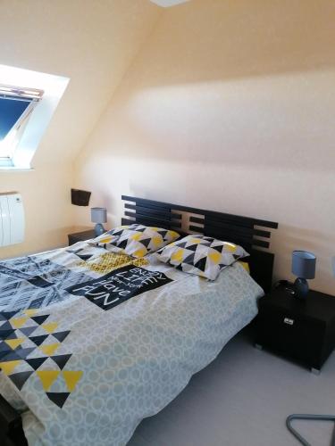 - une chambre avec un lit et une couette noire et jaune dans l'établissement LES HAUTS VENTS, à Saint-Pol-de-Léon