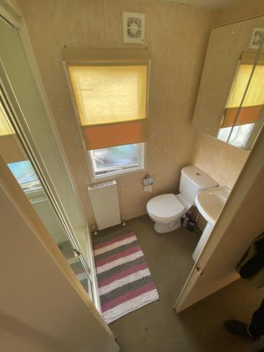 a small bathroom with a toilet and a sink at Lake District Static Caravan Lakeside Cumbria in Millom