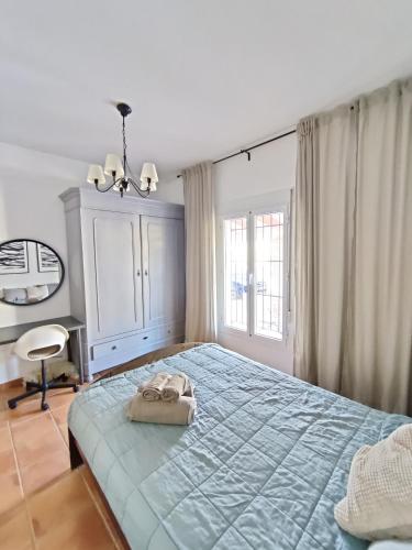 a bedroom with a blue bed with a bag on it at Casa Gala - Caminito del Rey in Málaga