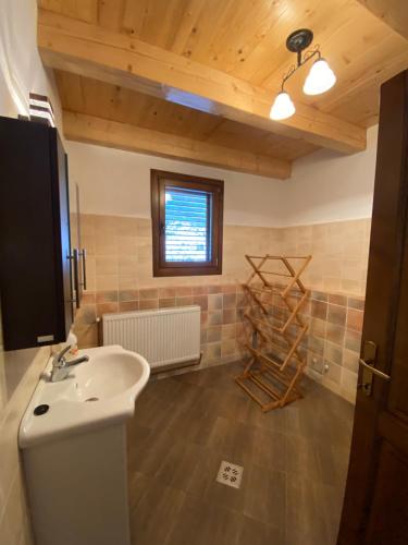 a bathroom with a white sink and a window at Szálka Kulcsosház in Lunca de Sus