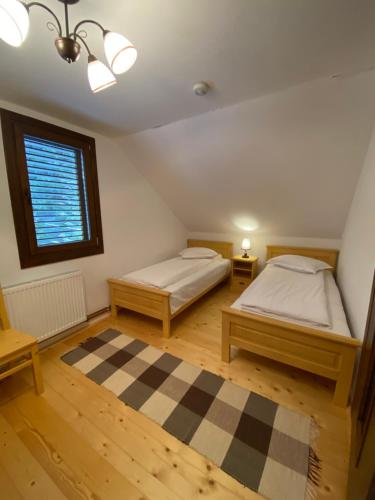a bedroom with two beds and a window at Szálka Kulcsosház in Lunca de Sus