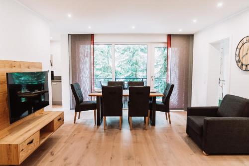 a dining room with a table and chairs and a television at My Lodge Winterberg in Winterberg