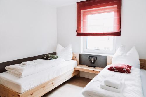 two beds in a room with a window at My Lodge Winterberg in Winterberg