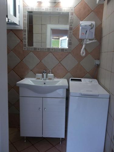 a bathroom with a sink and a washing machine at Sminos Farm House E4 path, Γυθειο in Monakhí Sikiá