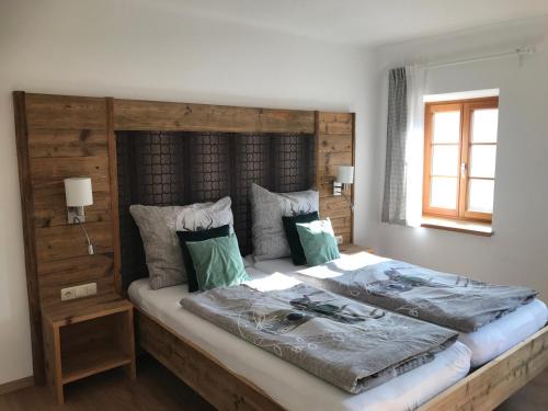 Schlafzimmer mit einem großen Bett mit einem Kopfteil aus Holz in der Unterkunft Landhaus Aigner in Allhartsberg