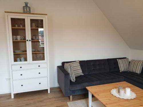 希斯利茲的住宿－Ferienwohnung Vogels Mühle，客厅配有黑色沙发和桌子