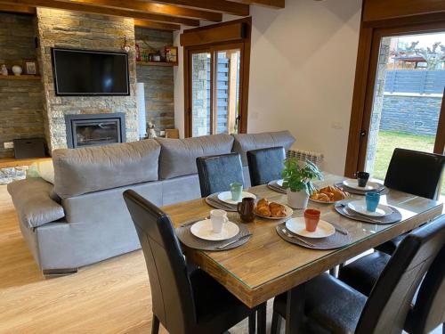 - un salon avec une table, des chaises et un canapé dans l'établissement Maison Cerdagne, à Bourg-Madame