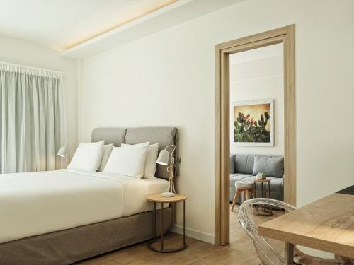a bedroom with a large bed and a mirror at NLH Mati Seafront - Neighborhood Lifestyle Hotels in Mati