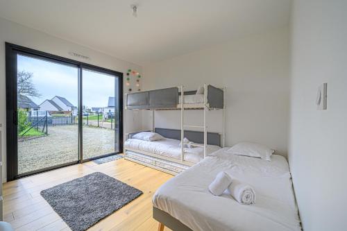 a bedroom with a bed and a large window at LE GRAIN DE CHARME - Maison contemporaine proche golfe du Morbihan in Sarzeau