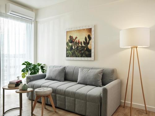 a living room with a couch and a painting on the wall at NLH Mati Seafront - Neighborhood Lifestyle Hotels in Mati
