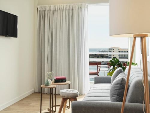 a living room with a couch and a large window at NLH Mati Seafront - Neighborhood Lifestyle Hotels in Mati