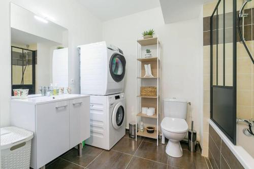 a bathroom with a washing machine and a toilet at Le Carrousel in Dijon