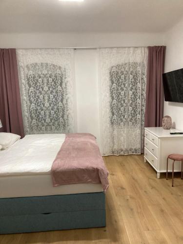 Schlafzimmer mit einem Bett, einer Kommode und Vorhängen in der Unterkunft Altes Bürgerhaus in Dürnstein