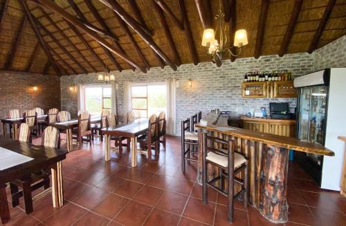 ein Restaurant mit Tischen und Stühlen und eine Bar in der Unterkunft Charihandra Game Lodge in Addo