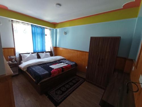 Un dormitorio pequeño con una cama y una ventana. en Tseten's Inn, en Lachung