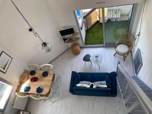 una vista aérea de una sala de estar con un sofá azul en Joli appartement 4 personnes - vue mer en Ploemeur