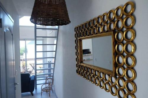 un espejo colgado en una pared junto a una escalera en Joli appartement 4 personnes - vue mer en Ploemeur