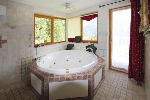 a large bathroom with a large tub and windows at Chalet in Hochkrimml in Krimml