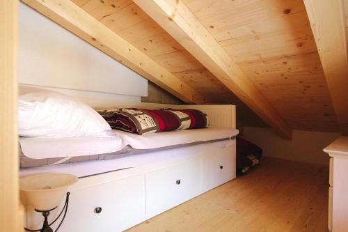a bed in a room with a wooden ceiling at Chalet in Hochkrimml in Krimml