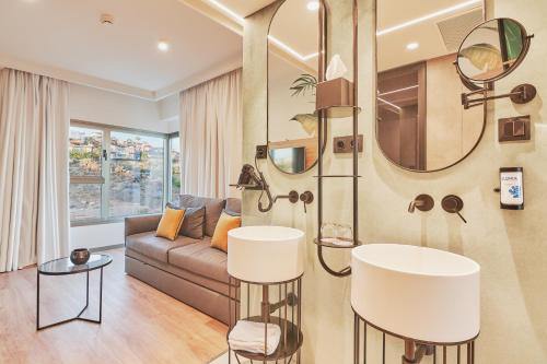 a living room with a couch and a mirror at Gloria Palace San Agustín Thalasso & Hotel in San Agustin