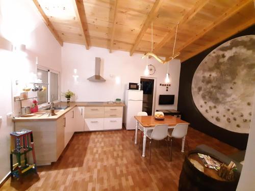 CASA LA LUNA في Isora: مطبخ بدولاب بيضاء وطاولة خشبية