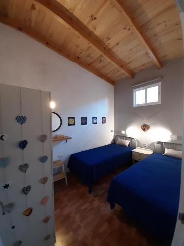 two beds in a room with wooden ceilings at CASA LA LUNA in Isora