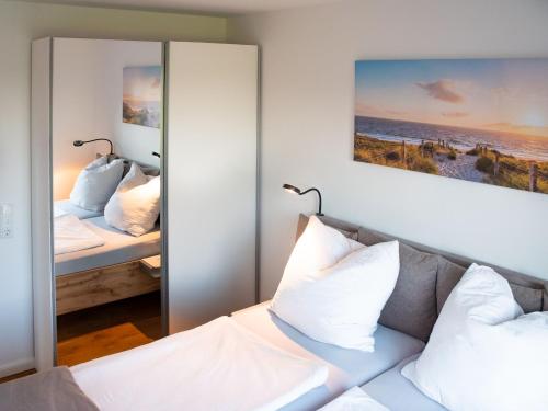 een slaapkamer met 2 bedden en een spiegel bij Ferienhäuser Rüno in Bergen auf Rügen