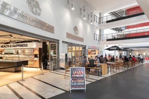 a shopping mall with people sitting at tables in it at Icon Luxury Apartments in Cape Town